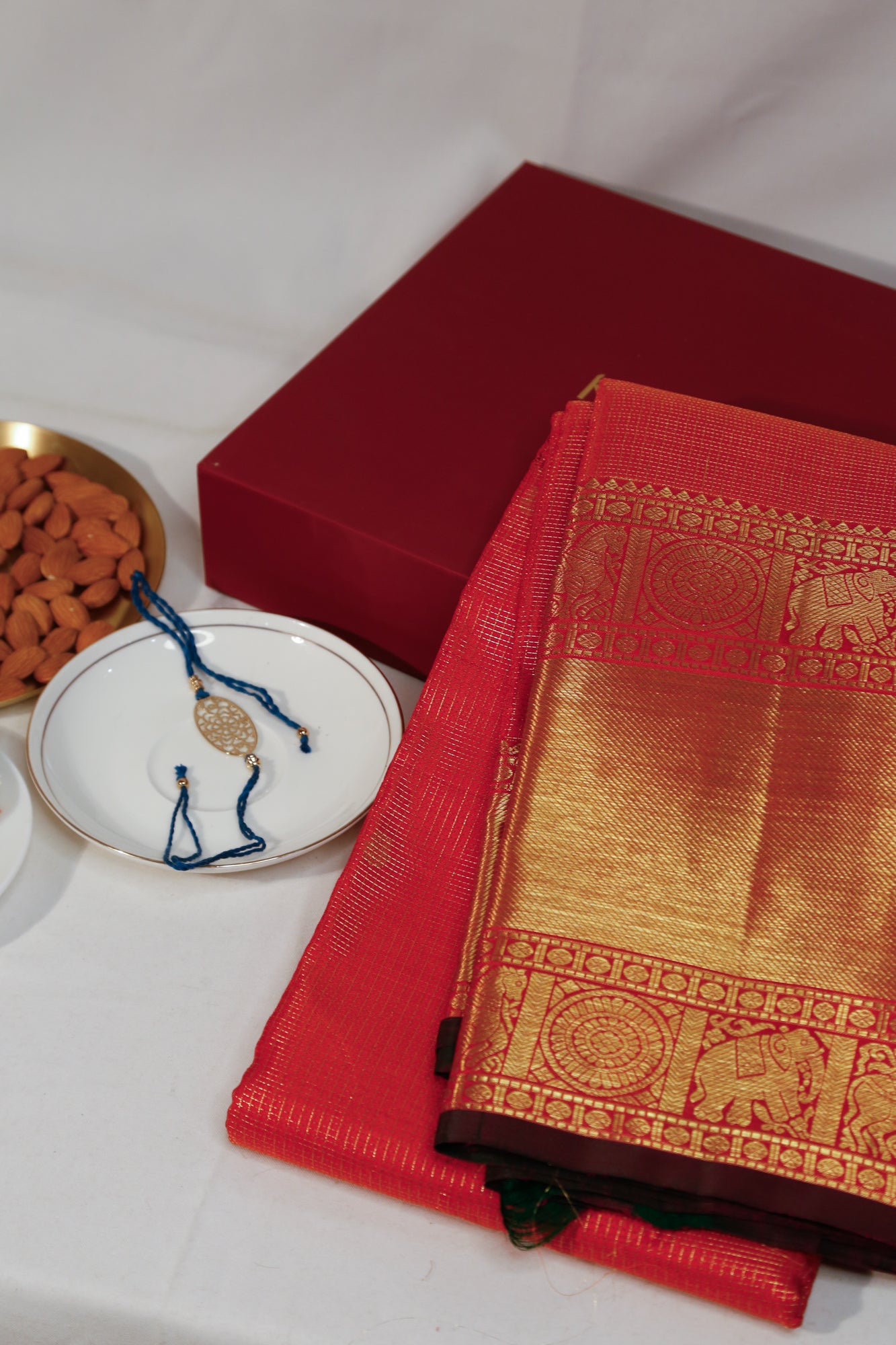 Taranga Kanchi Silk Checks And Butta Dual Tone Orange And Pink Saree With Gift Box And Rakhi